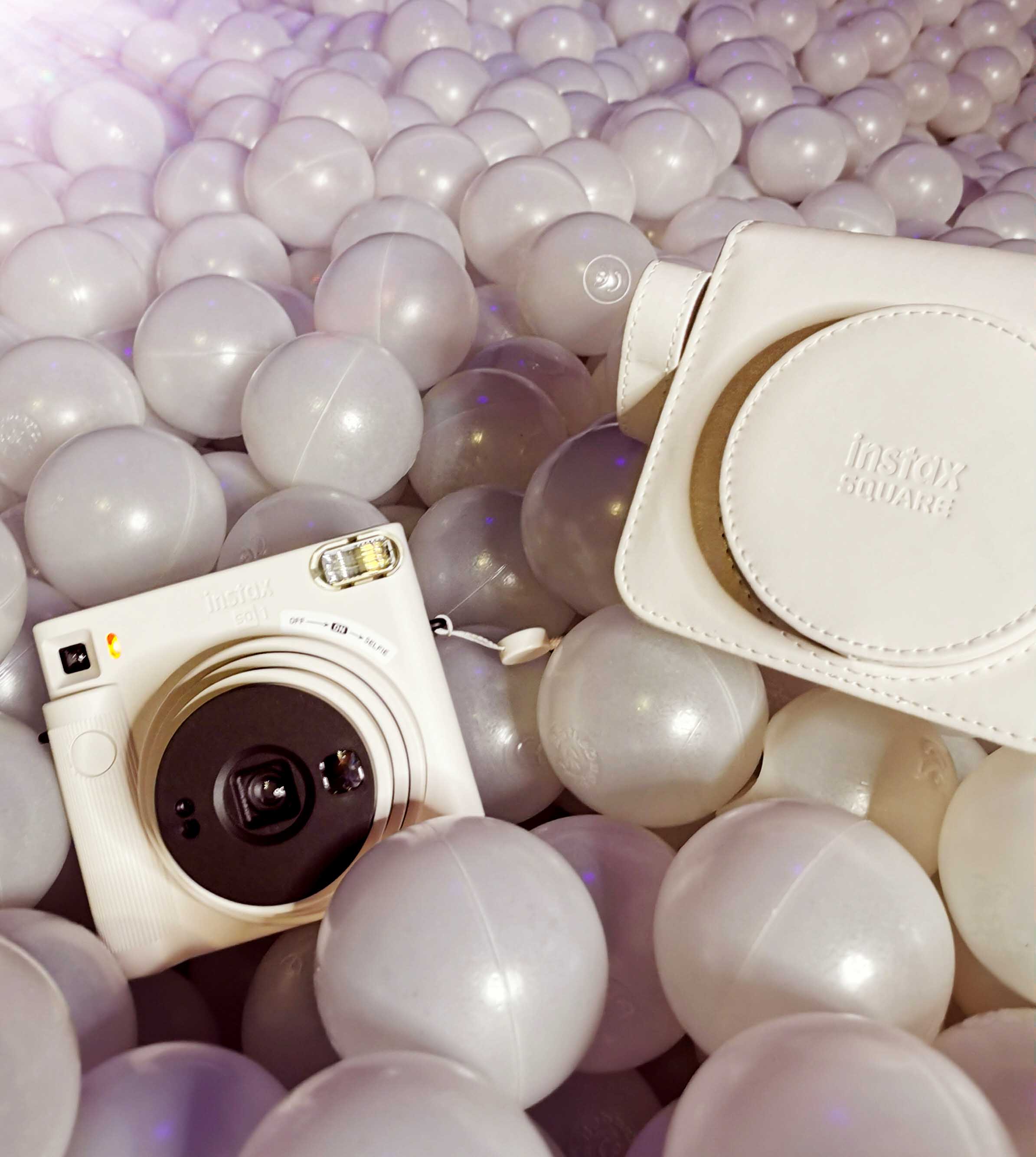 Kamera mit passenderTragetasche in beige in einem Bällebad